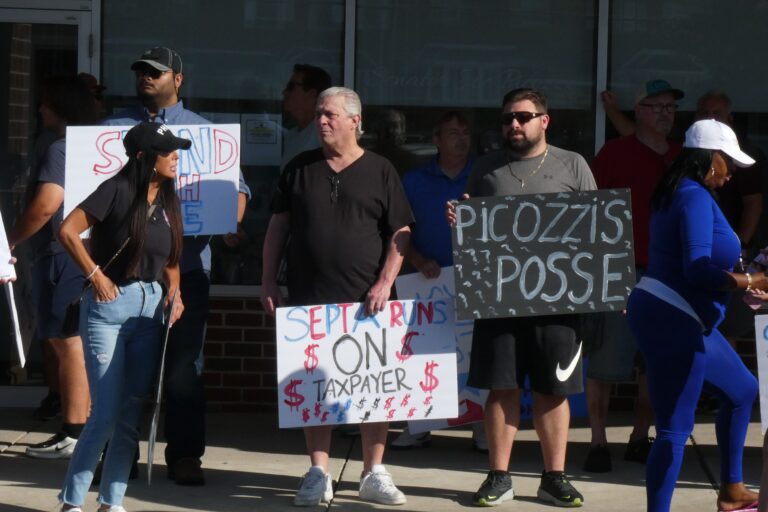Supporters of Picozzi hold signs outside his office