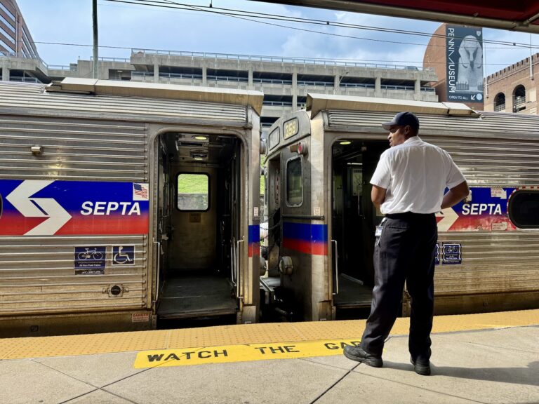 A SEPTA employee monitors trains at a regional rail platform