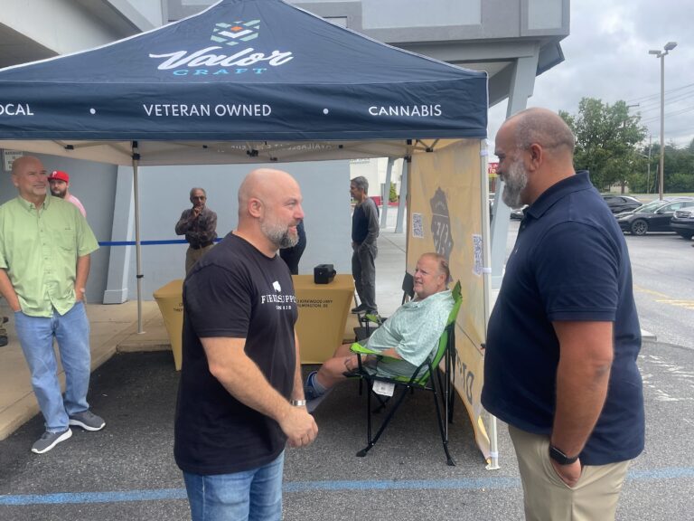 Two men speaking in front of a store