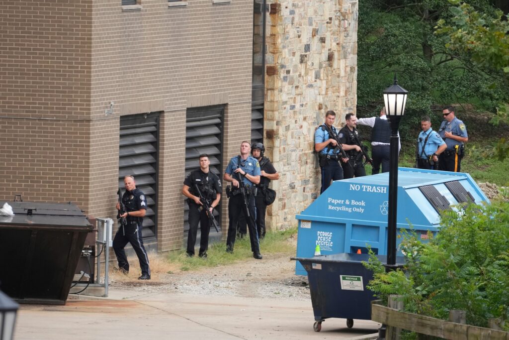 Police officer lining up behind a wall with their guns