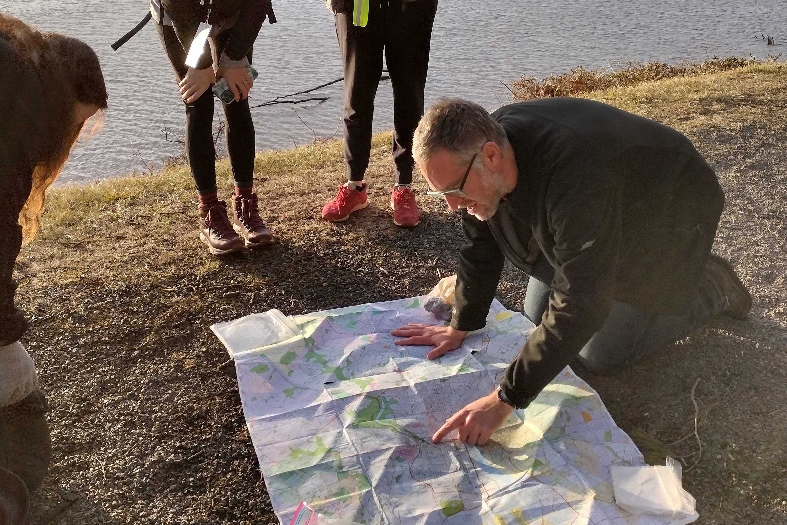 JJ Tiziou looking at a map on the ground
