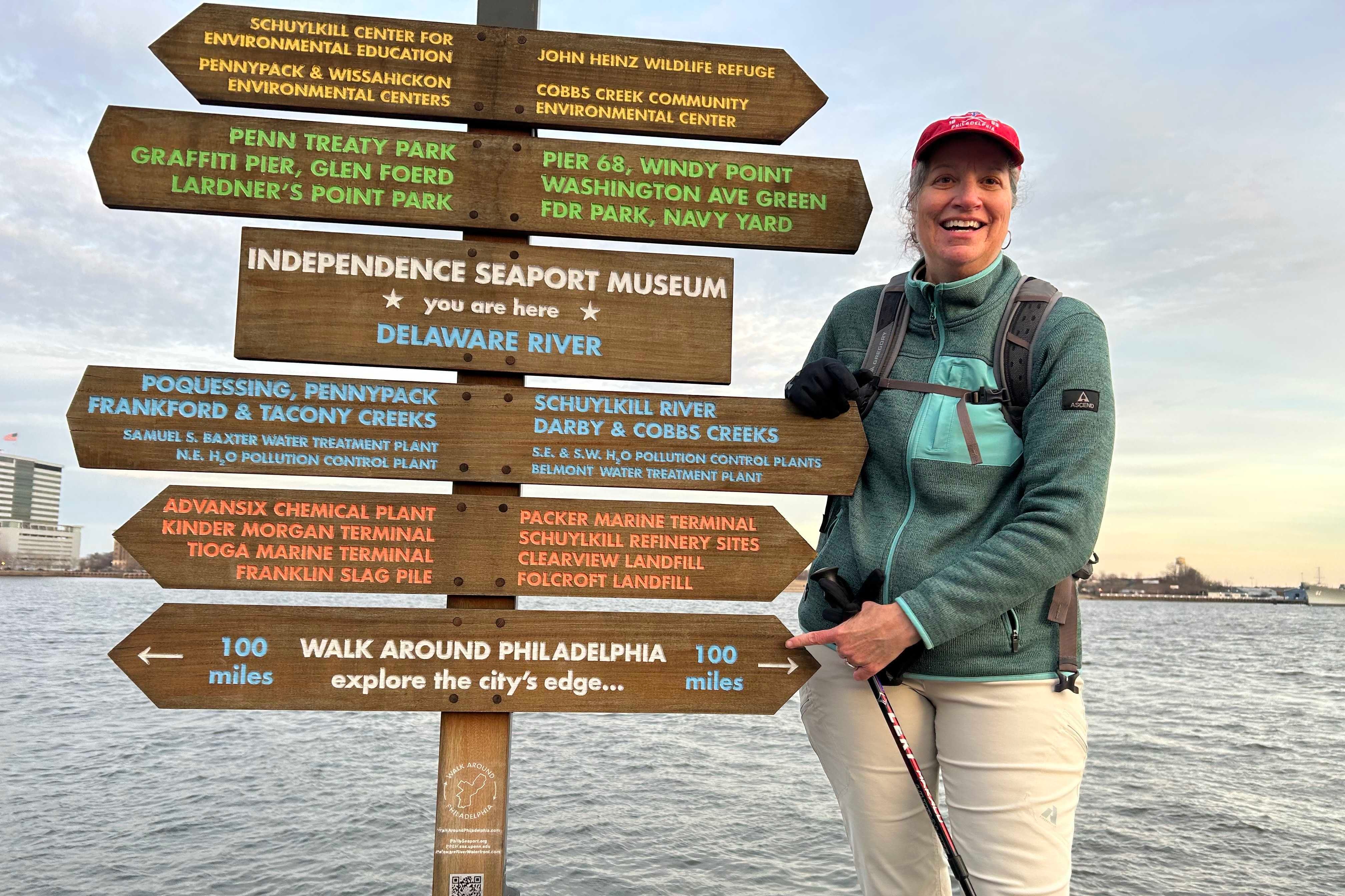 Lisa Hardy smiles and stands by the first Walk Around Philadelphia wayfinding installation