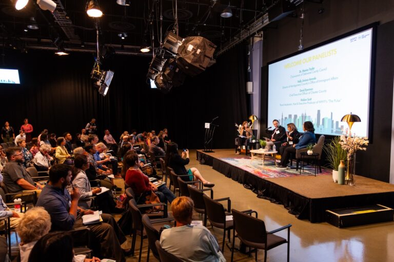 Four people sitting on stage for the panel discussion