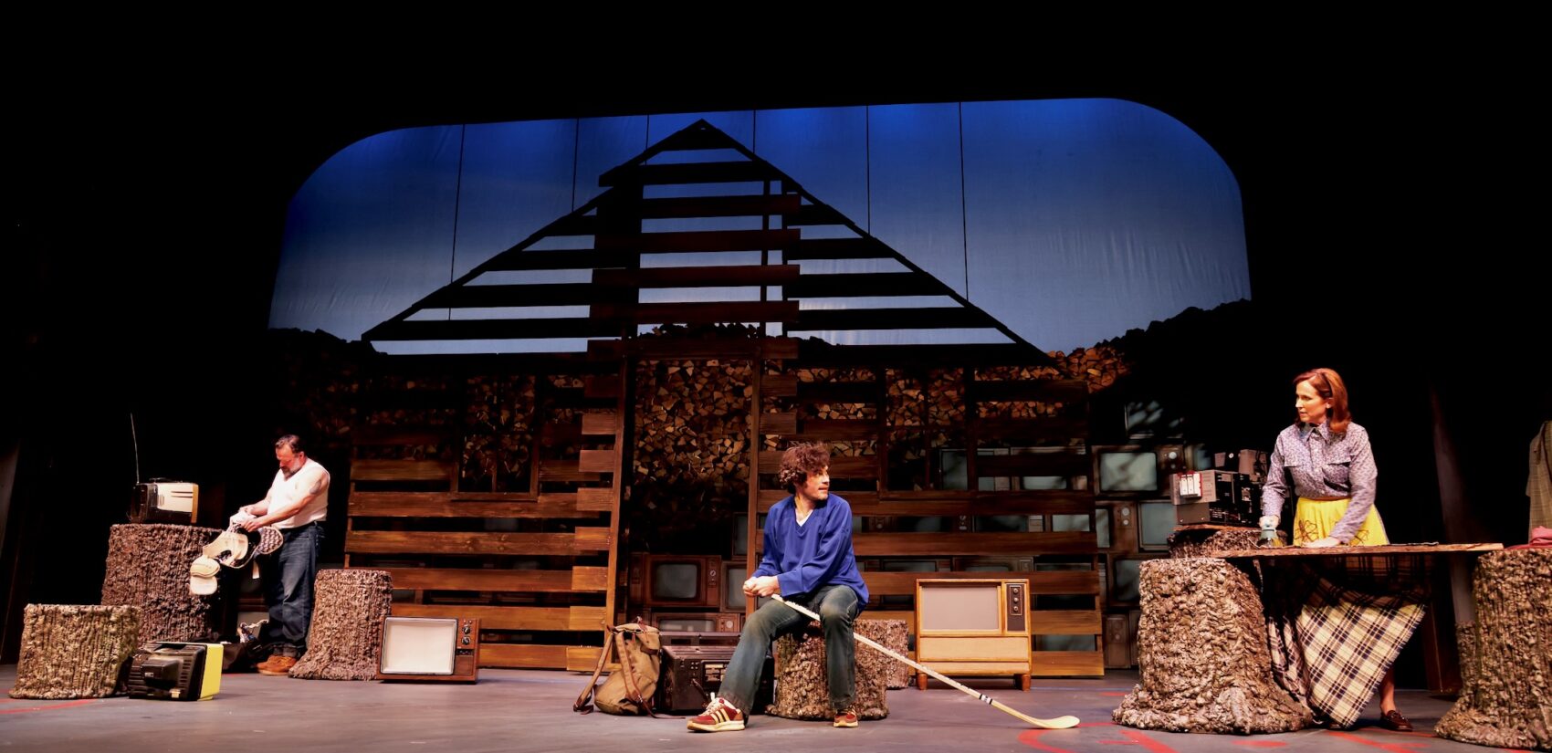 Three people on stage performing a scene from the play