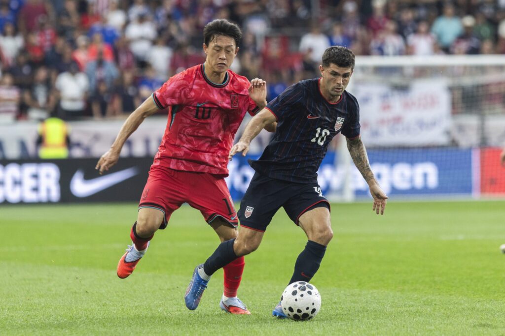 Two soccer players fight for the ball