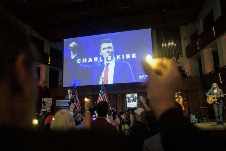 People hold candles and sing during a memorial and prayer vigil for Charlie Kirk at the John F. Kennedy Memorial Center for the Performing Arts, Sunday, Sept. 14, 2025, in Washington. (AP Photo/Rod Lamkey, Jr.)