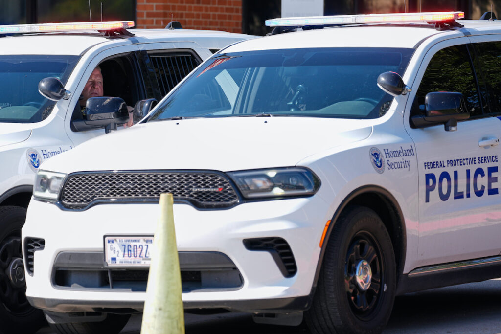 Homeland security personnel sit in their vehicles
