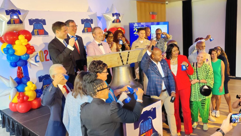 City officials celebrate in front of a replica of the Liberty Bell