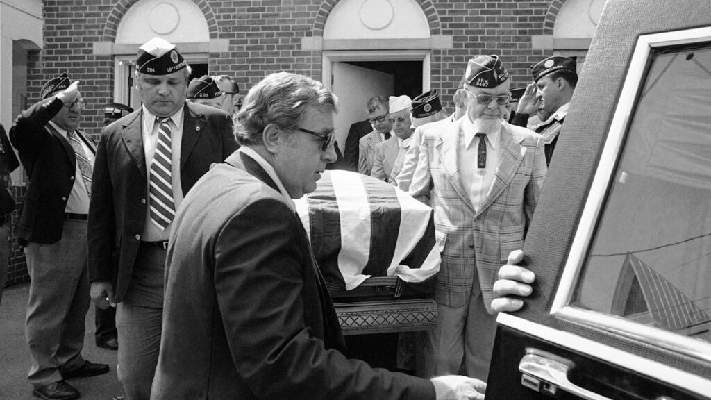 Legionnaires-death-funeral-file-ap-1976 Members of various veteran organizations carry flag-draped casket of J.B. Ralph from funeral home in Williamstown, Pennsylvania