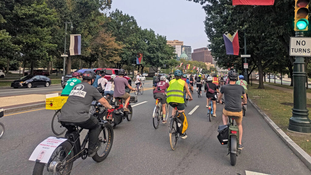 A group of cyclists ride their bikes through Philadelphia