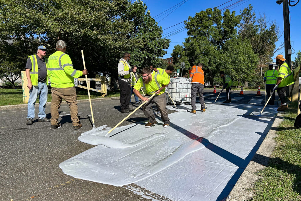 cool-pavement-s-schmidt-2025-09-16-6 Workers spread the white coating along the road