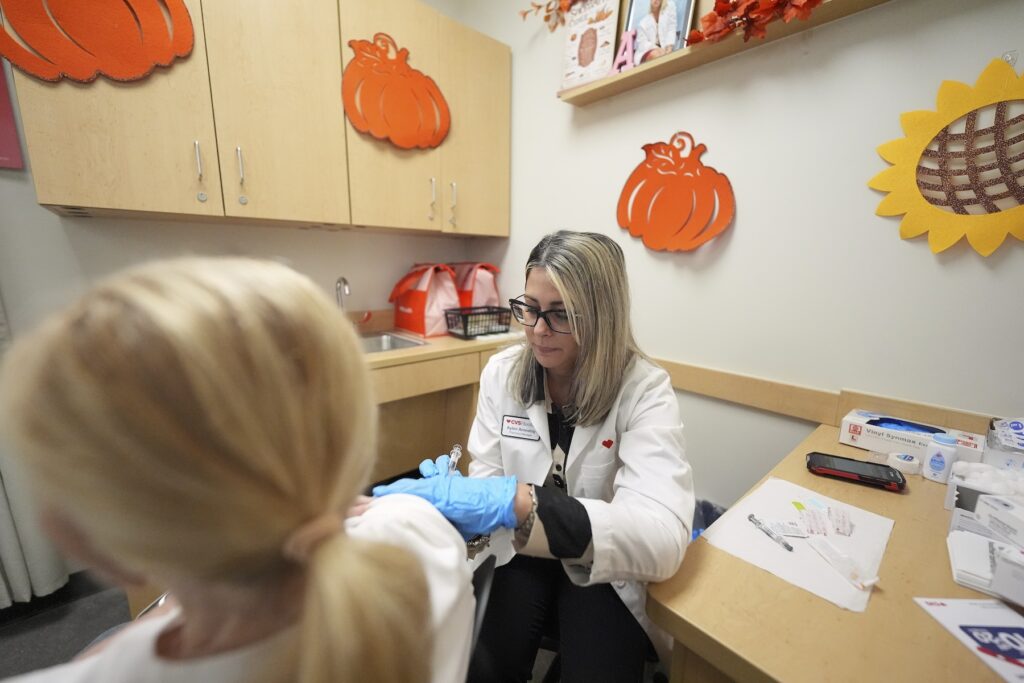 Pharmacy manager Aylen Amestoy administers a patient with a COVID-19 vaccine