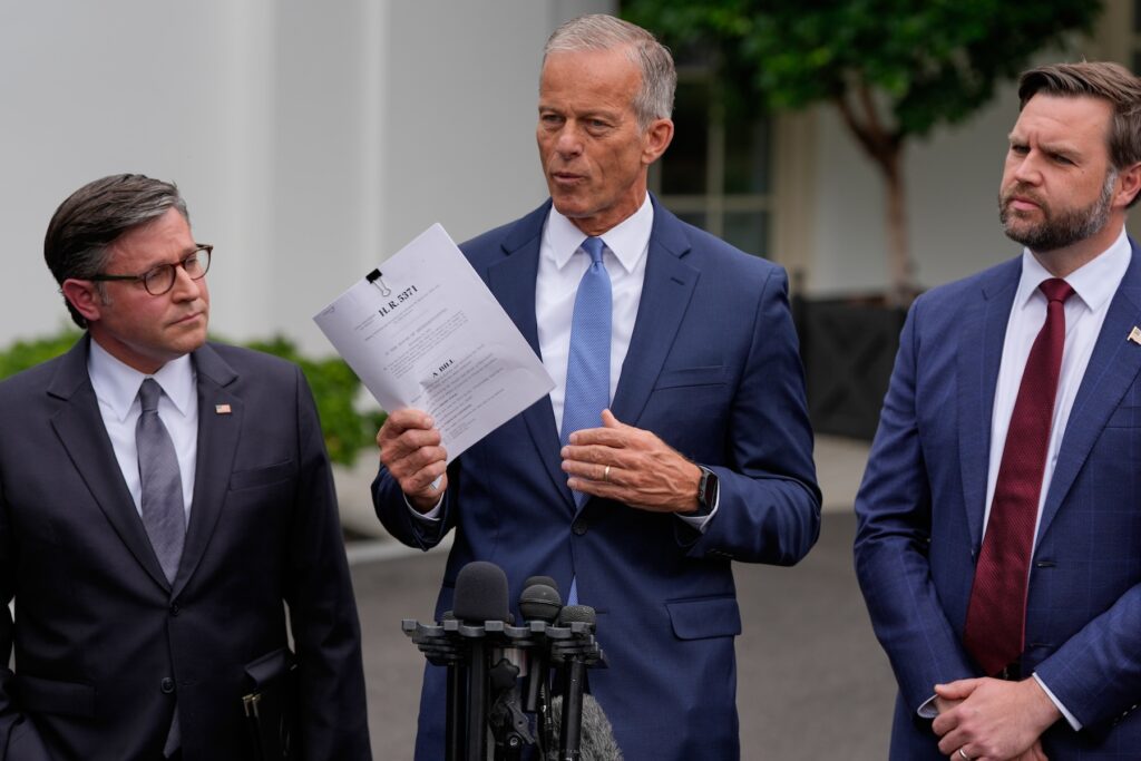 Trump Congress Shutdown John Thune speaking, with Mike Johnson and JD Vance standing on either side of him during a press conference