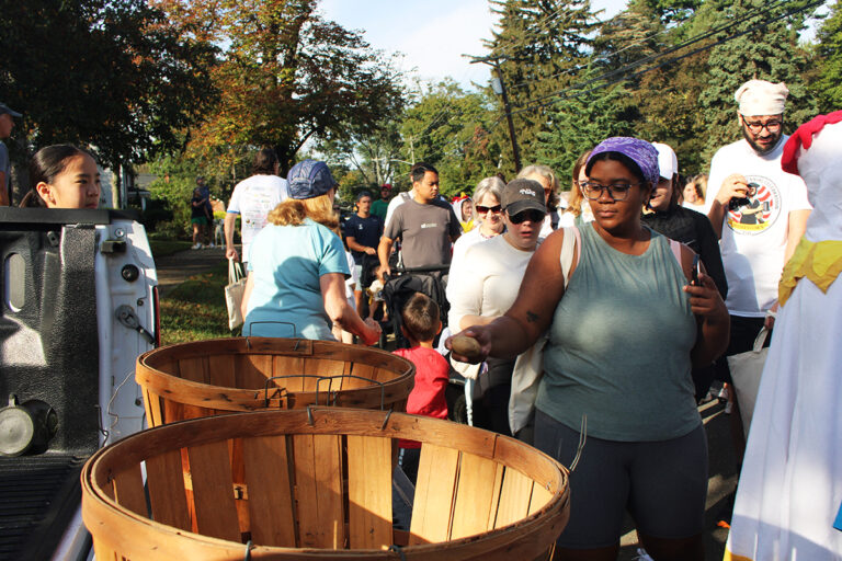 A woman drops a potato in a bucket