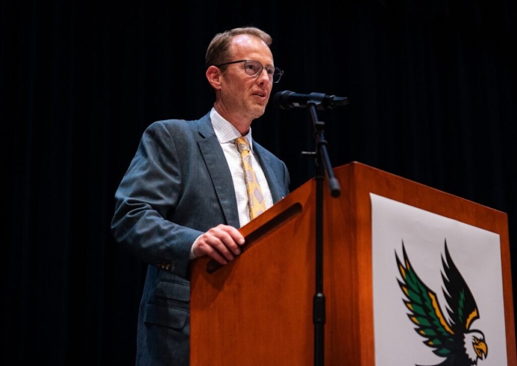 Matthew Burrows speaking at a podium