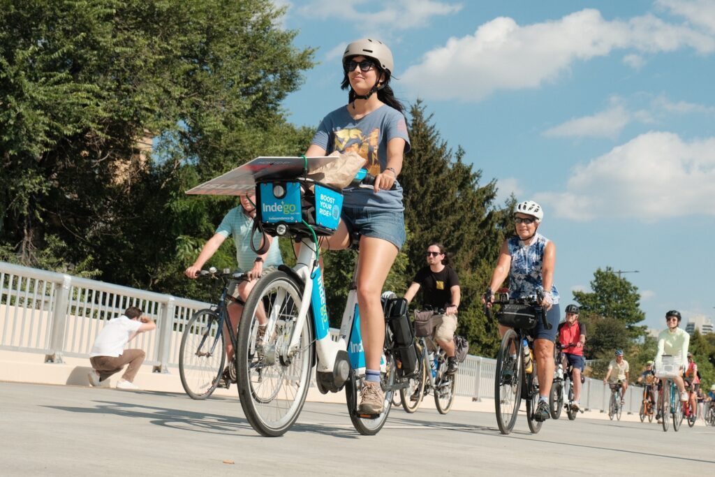 People riding their bikes across the brige