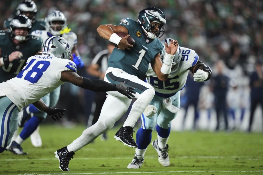 APTOPIX Cowboys Eagles Football Philadelphia Eagles quarterback Jalen Hurts (1) runs the ball as Dallas Cowboys' Damone Clark (18) and Kenny Clark (95) attempt to make the stop in the first half of an NFL football game Thursday, Sept. 4, 2025, in Philadelphia