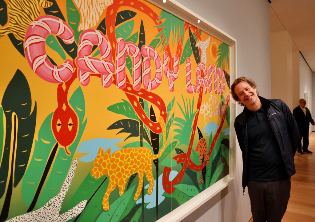 Joel Mesler stands beside his 2023 screenprint, ''Candy Land