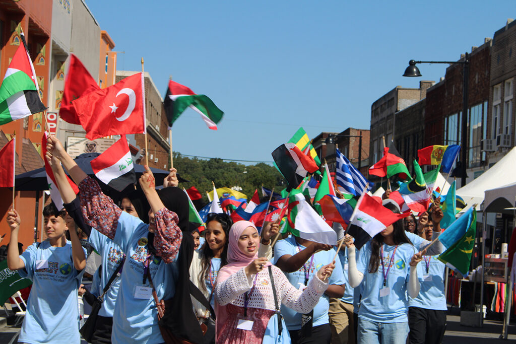 Children and community members parade with flags from different countries in front of the municipal building at Upper Darby's International Festival on Sept. 20, 2025.