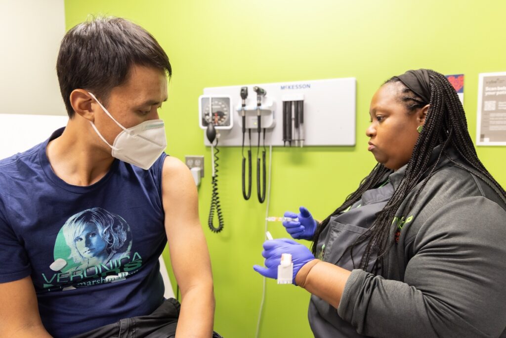WHYY’s the Pulse reporter Alan Yu receives his influenza vaccine at a Vybe urgent care center in Philadelphia. (Kimberly Paynter/WHYY)