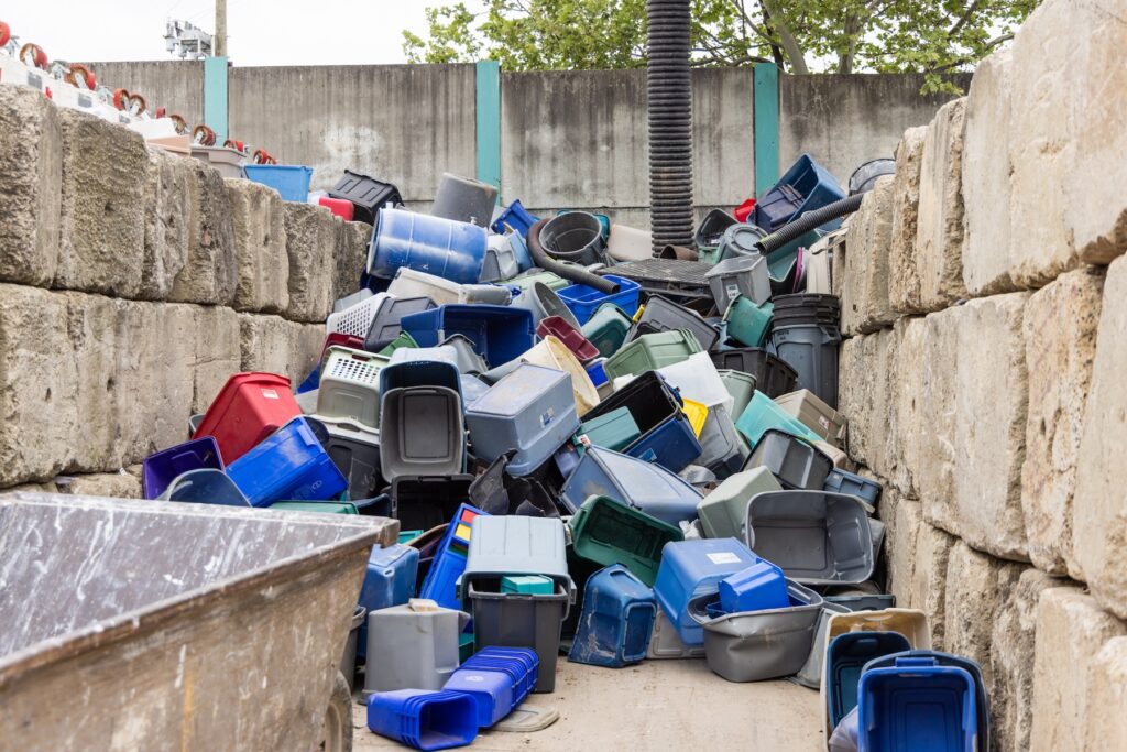 A large stack of bins piled up against the wall