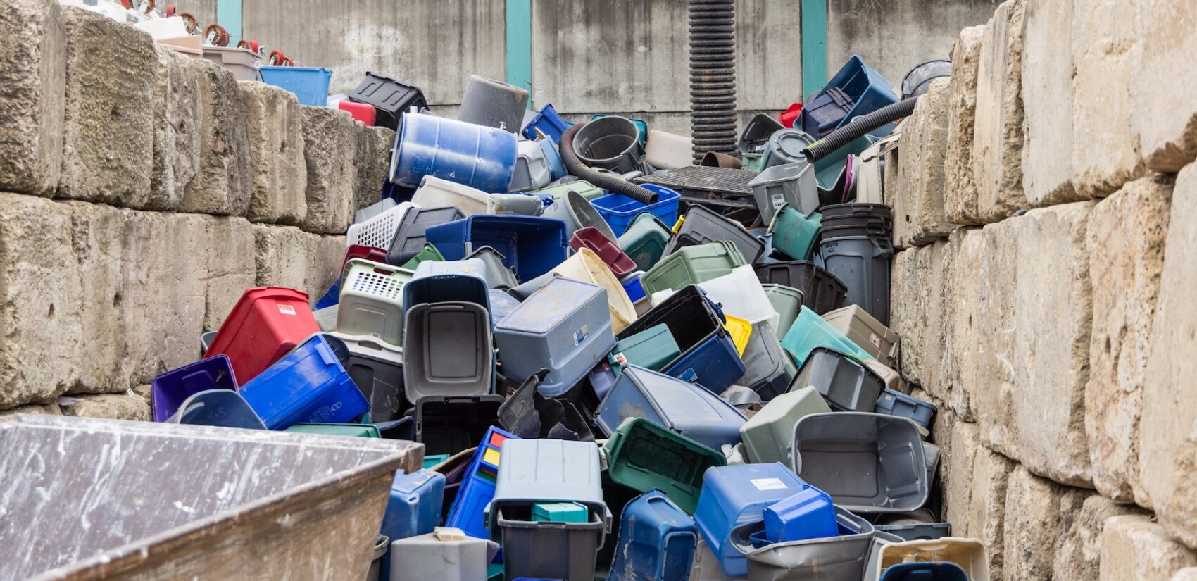 A large stack of bins piled up against the wall