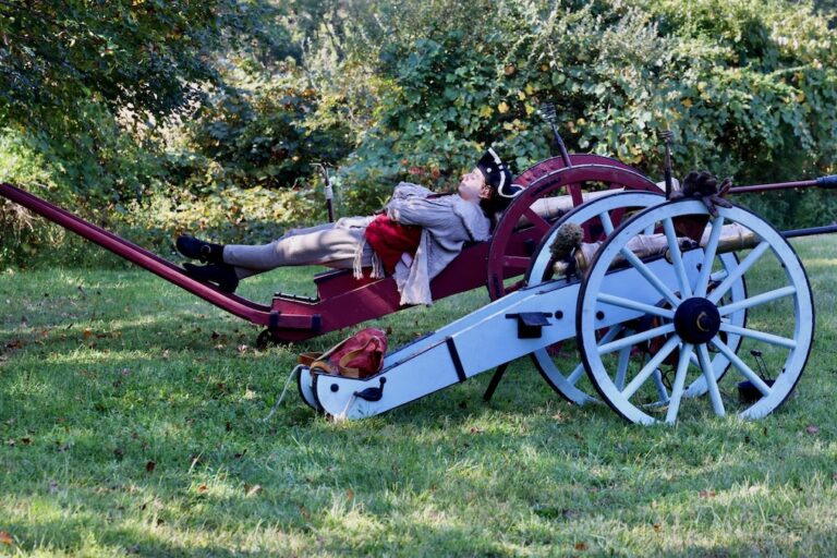 A Revolutionary War reenactor lounges on his cannon