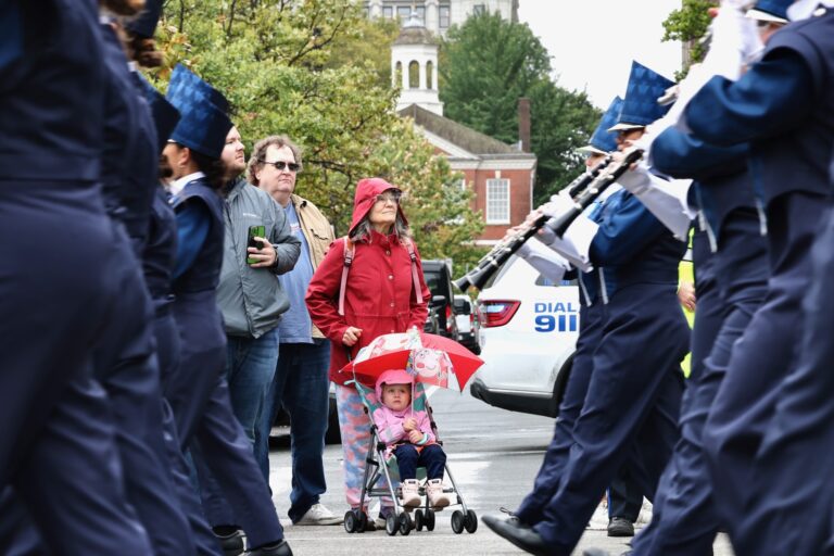 Spectators watch as the West Shore marching band passes during the Navy and Marine Corps 250th anniversary parade