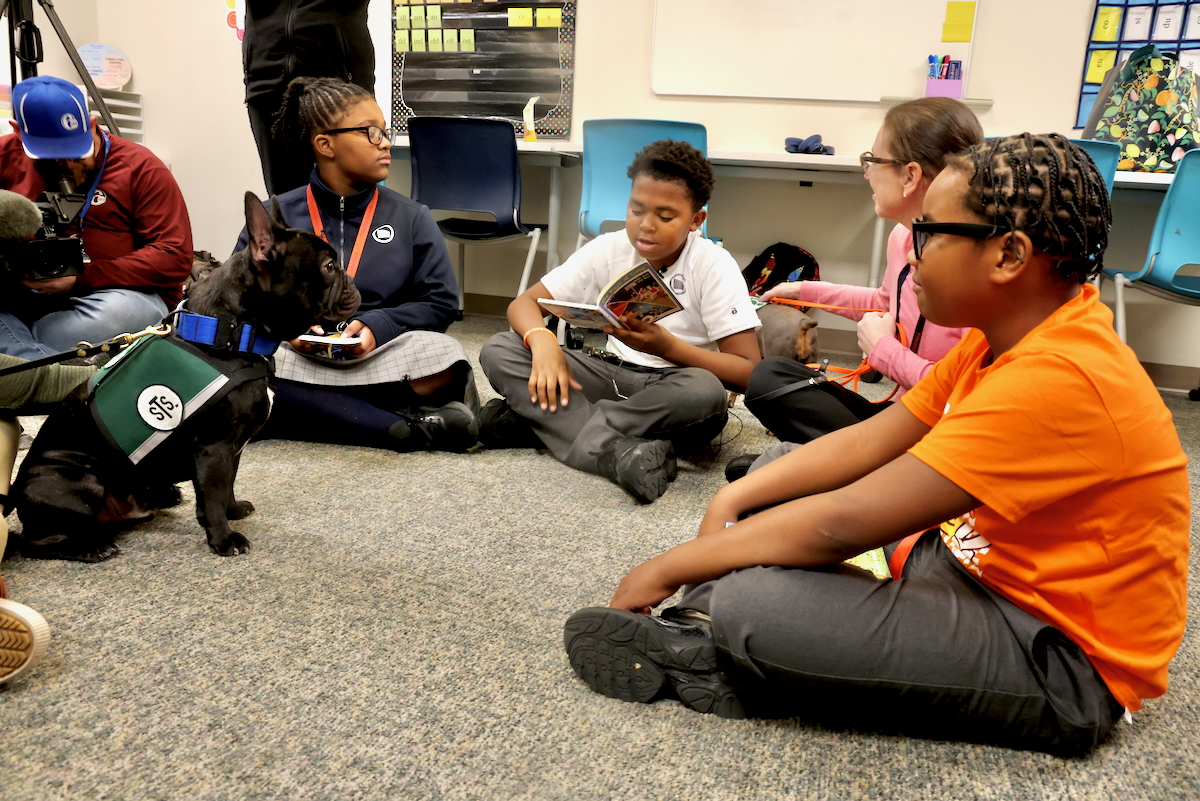 students sitting with String Theory School therapy dogs