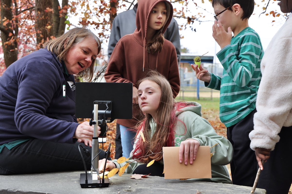 Beth Clark (left) showing students how to use a digital microscope