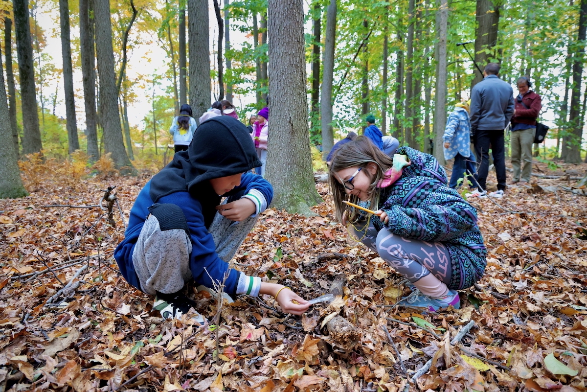 ucker Leonard (left) and Kailyn Little look for signs of life in the leaf litter during an outing