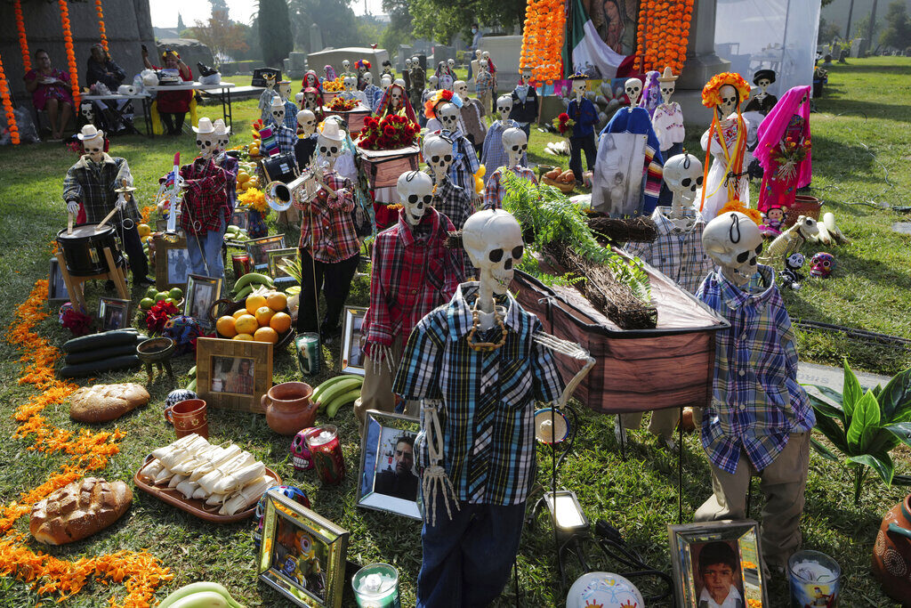 A reenactment of a funeral procession by skeletons is displayed at a gravesite during the festivities for the Day of the Dead