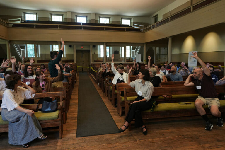 Quakers raise their hands after a worship service at the historic West Room of the Arch Street Meeting House in Philadelphia