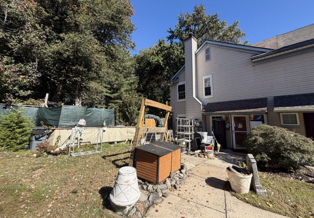 The exterior of the house, with a junk-filled yard