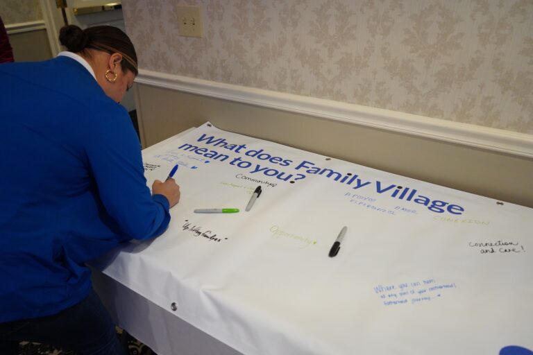 Event attendees sign a banner