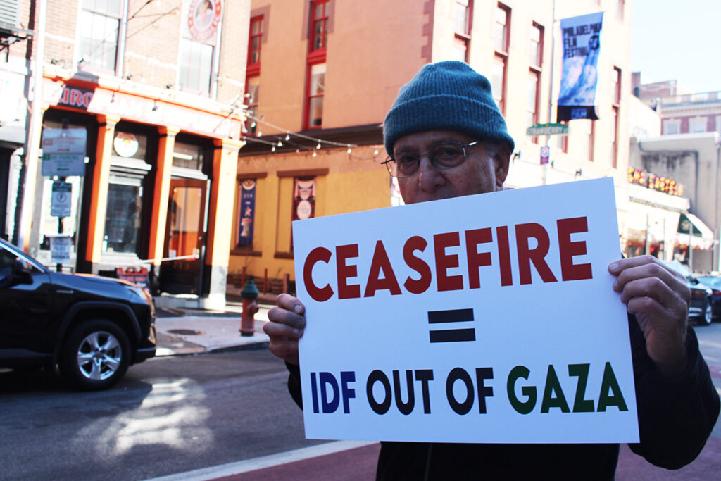 Maynard Seider holds up a sign that reads "Ceasefire = IDF out of Gaza"