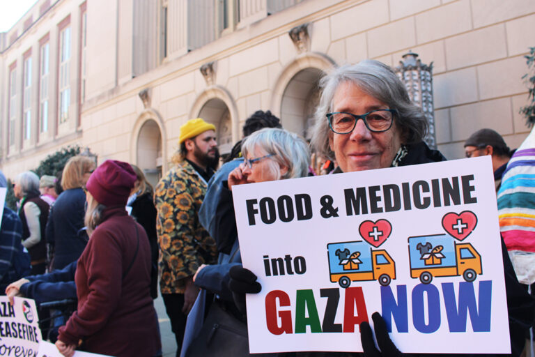 Betsey Piette holds a sign that reads 