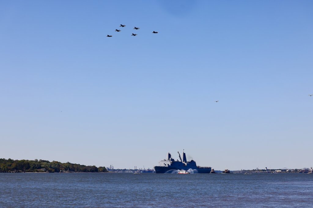 A Navy ship in the Delaware River with planes flying overhead