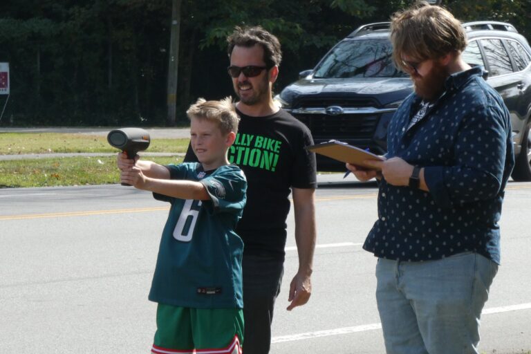 a child holds a radar gun