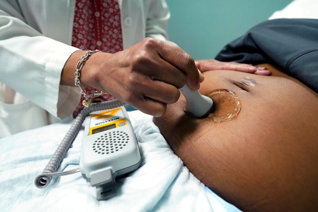 Climate Heat Farmworkers Pregnancy Takeaways A doctor uses a hand-held Doppler probe on a pregnant woman