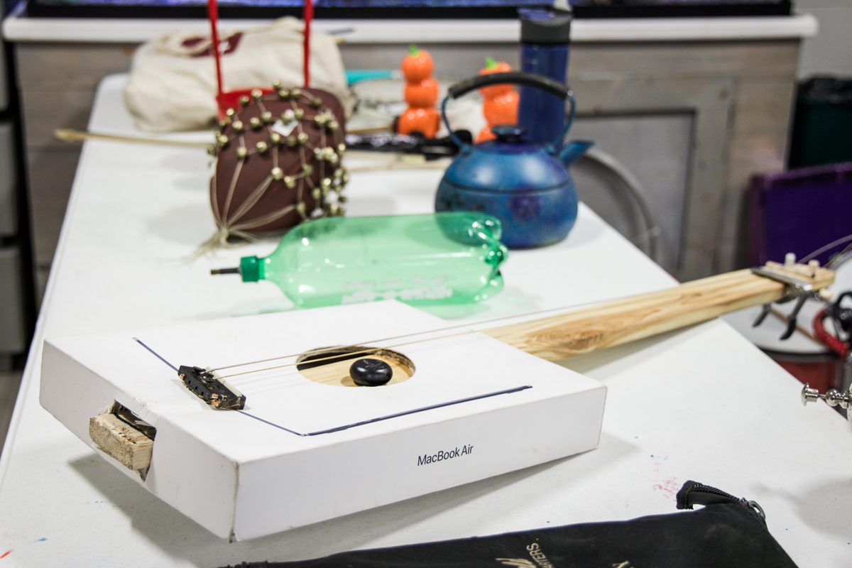 a playable bass guitar made from a MacBook Air box, a football tamborine, a soda bottle whistle and a tea kettle drum