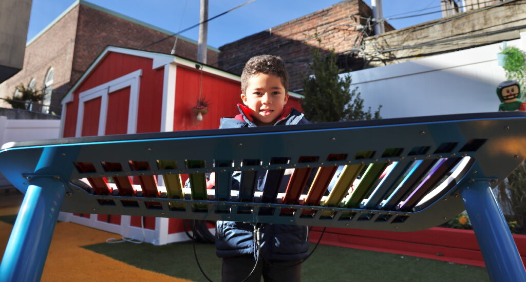 2025 11 14-e lee-adam kaddai-philadelphia performing arts charter school-sensory garden xylophone a child plays a xylophone
