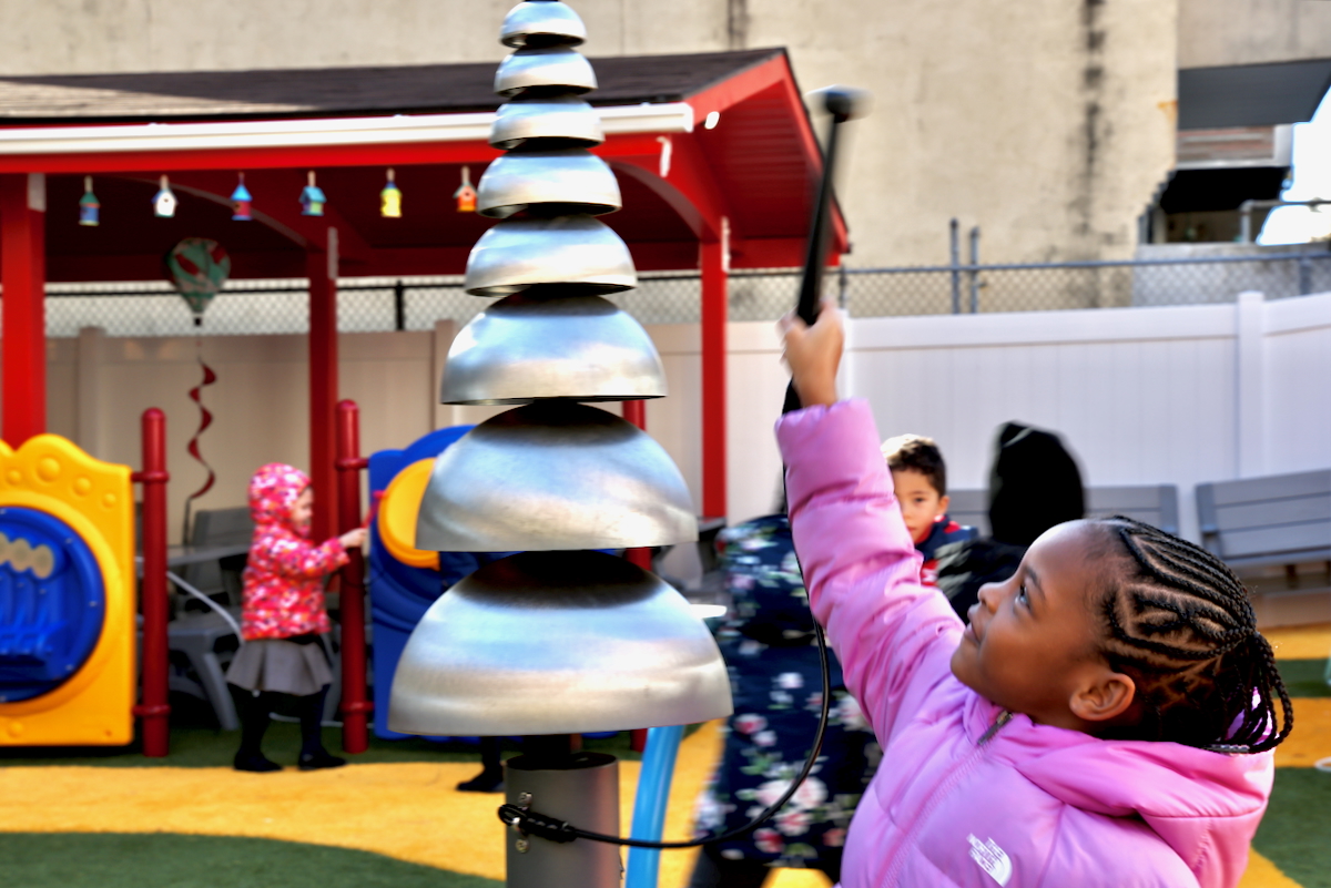 a child plays with metal bells