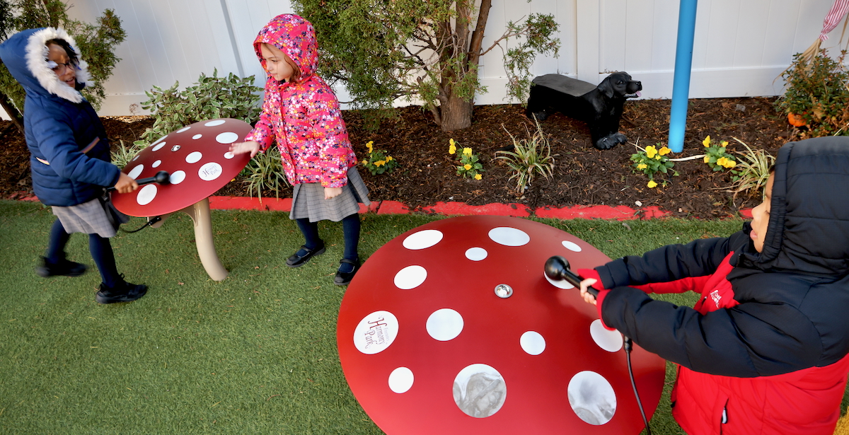 children playing with mushroom-shaped metal drums