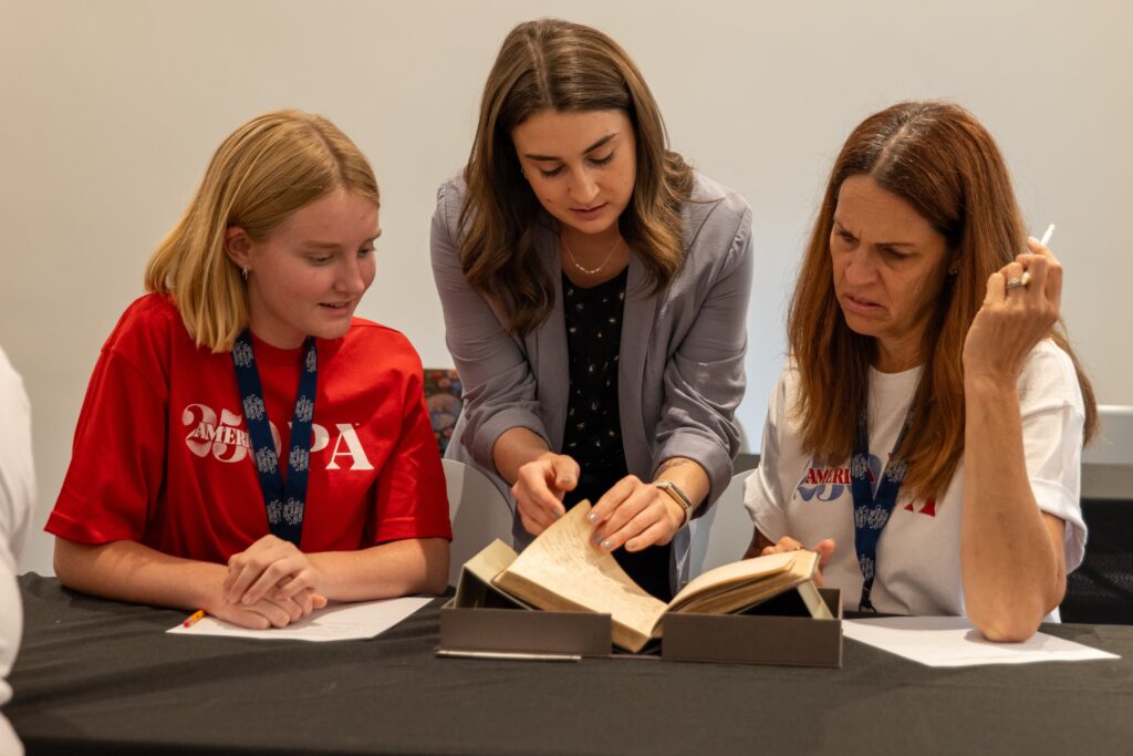 Three people looking at a book