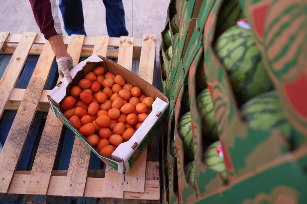 Government Shutdown Food Bank A volunteer reaches for a box of tomatoes