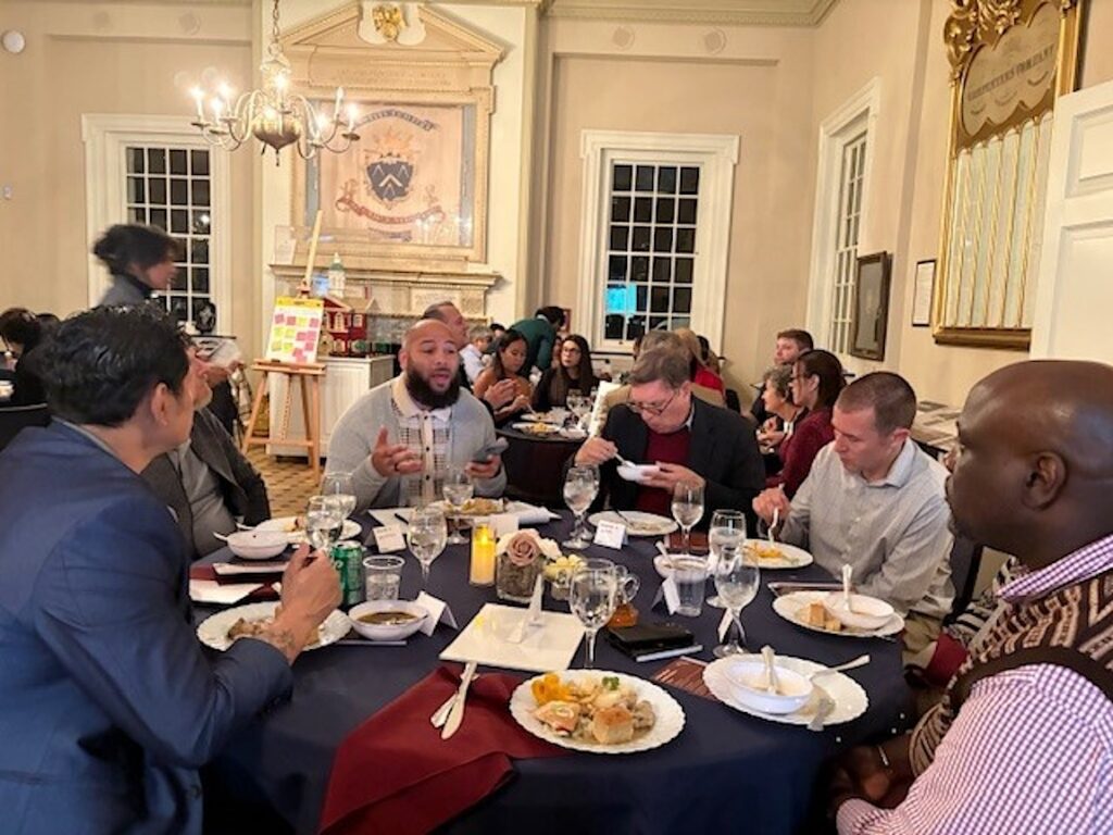 breaking bread pilot 5 People sitting around a large round table eating