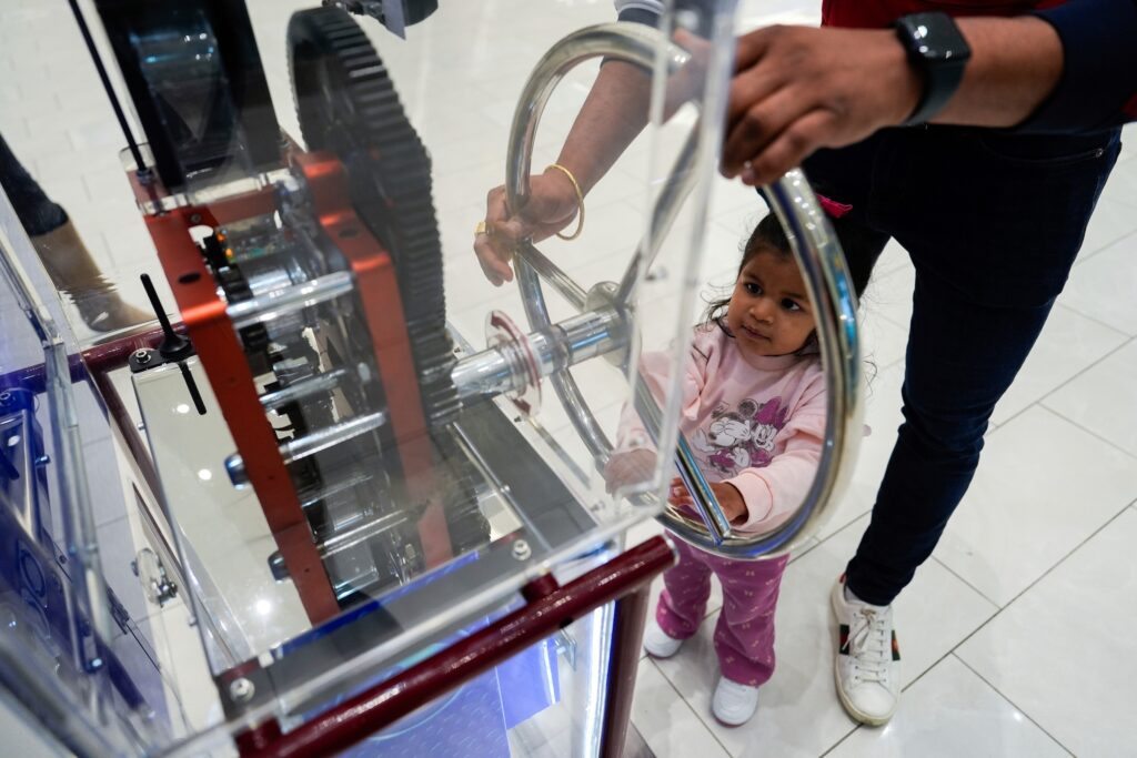 Death of the Penny A girl and a parent use a penny press machine
