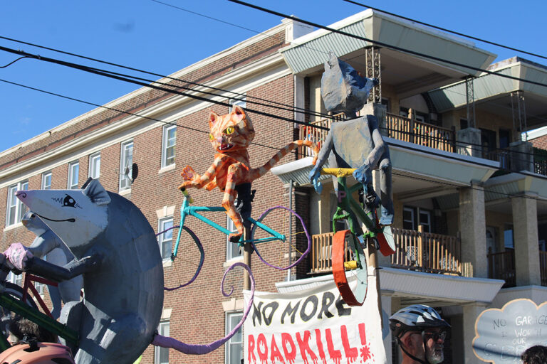 People hold up homemade figures of animals on bicycles at the 25th annual Peoplehood Parade in West Philadelphia