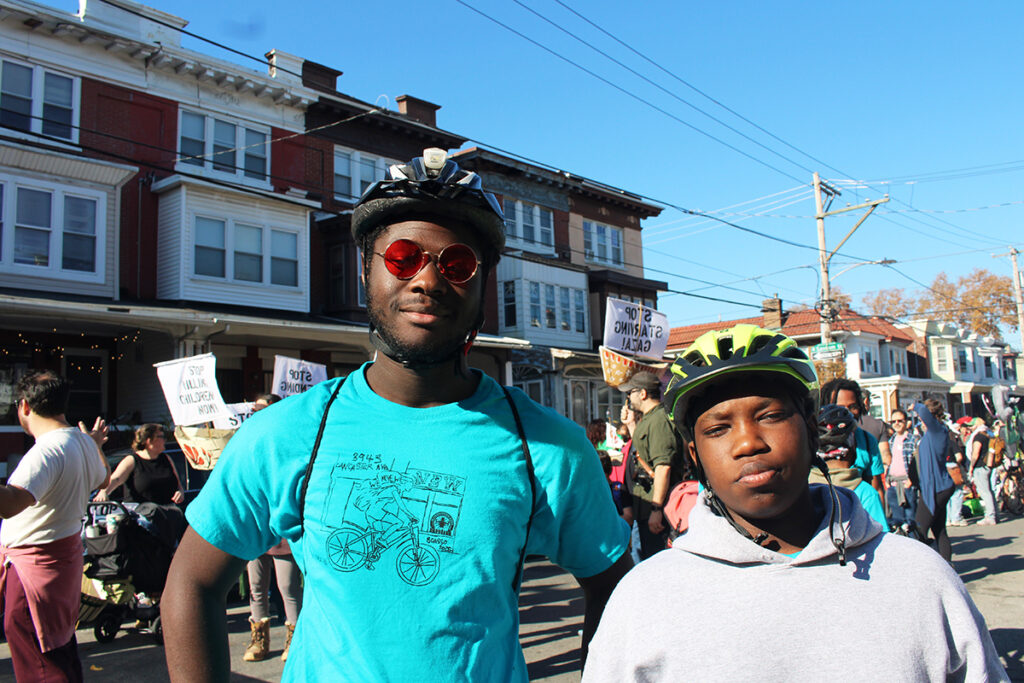 Mamady Toure, left, and Asad Abdurrahim, right, pose for a photo while marching in the 25th annual Peoplehood Parade in West Philadelphia